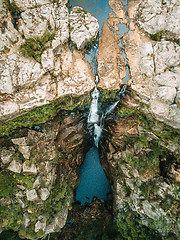 Image showing Overhead views waterfall flowing into rock pool at base of cliff