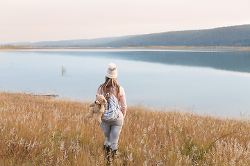 Image showing Woman in long soft grasses by lake Country Life