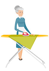 Image showing Caucasian maid ironing clothes on ironing board.