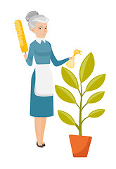 Image showing Caucasian housemaid watering flower with spray.