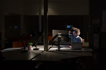 Image showing man working on computer in dark office