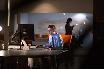 Image showing man working on computer in dark office