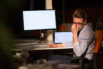 Image showing man working on computer in dark office