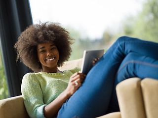 Image showing young african american woman at home using digital tablet