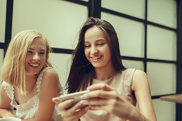 Image showing Two girl friends spend time together drinking coffee in the cafe, having breakfast and dessert.