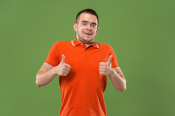 Image showing The happy businessman standing and smiling against green background.