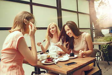 Image showing Two girl friends spend time together drinking coffee in the cafe, having breakfast and dessert.