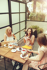 Image showing Two girl friends spend time together drinking coffee in the cafe, having breakfast and dessert.