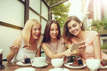 Image showing Two girl friends spend time together drinking coffee in the cafe, having breakfast and dessert.