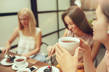 Image showing Two girl friends spend time together drinking coffee in the cafe, having breakfast and dessert.