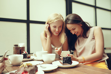 Image showing Two girl friends spend time together drinking coffee in the cafe, having breakfast and dessert.