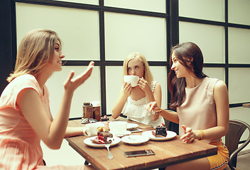 Image showing Two girl friends spend time together drinking coffee in the cafe, having breakfast and dessert.