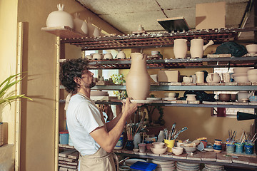 Image showing Creating a jar or vase of white clay close-up. Master crock.