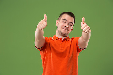 Image showing The happy businessman standing and smiling against green background.