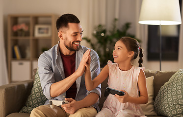 Image showing father and daughter playing video game at home