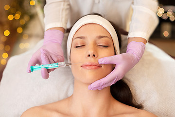 Image showing beautician doing beauty injection to woman lips