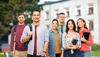 Image showing group of smiling students with books over campus