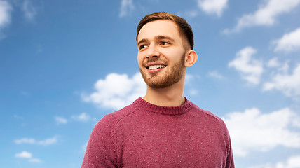 Image showing smiling young man over blue sky background