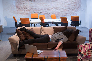 Image showing man sleeping on a sofa  in a creative office