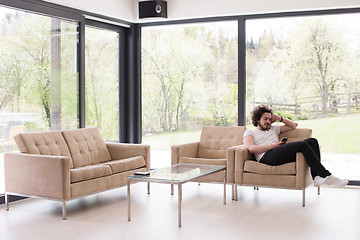 Image showing young man using a mobile phone  at home