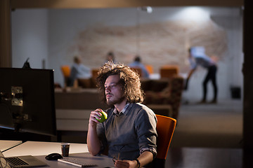 Image showing man working on computer in dark office