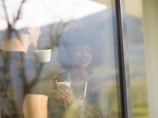 Image showing happy multiethnic couple relaxing at modern home indoors