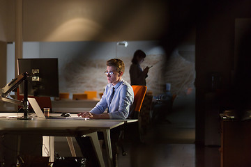 Image showing man working on computer in dark office