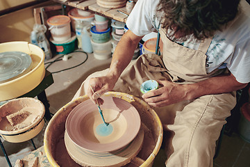 Image showing Creating a jar or vase of white clay close-up. Master crock.