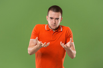 Image showing The young emotional angry and scared man standing and looking at camera