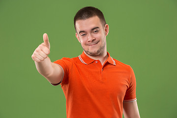 Image showing The happy businessman standing and smiling against green background.