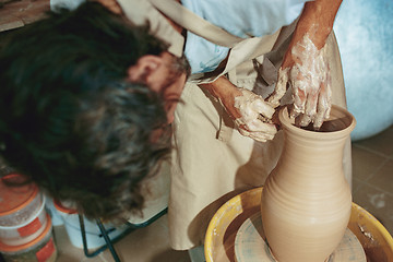 Image showing Creating a jar or vase of white clay close-up. Master crock.