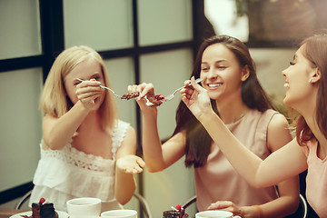 Image showing Two girl friends spend time together drinking coffee in the cafe, having breakfast and dessert.