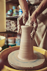 Image showing Creating a jar or vase of white clay close-up. Master crock. Man hands making clay jug macro.