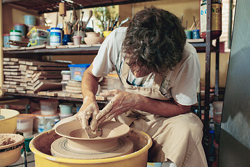 Image showing Creating a jar or vase of white clay close-up. Master crock.