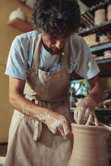 Image showing Creating a jar or vase of white clay close-up. Master crock.