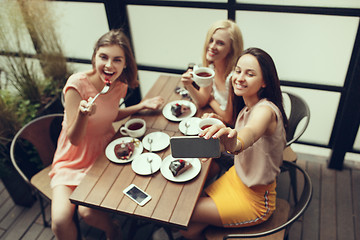 Image showing Two girl friends spend time together drinking coffee in the cafe, having breakfast and dessert.