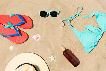 Image showing straw hat, flip flops and sunglasses on beach sand