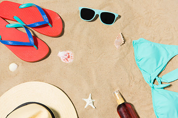 Image showing straw hat, flip flops and sunglasses on beach sand