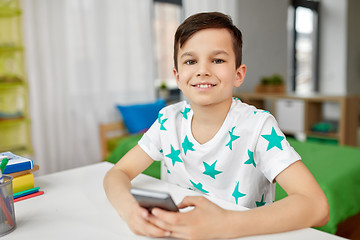 Image showing happy boy with smartphone at home