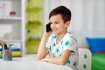 Image showing happy boy calling on smartphone at home