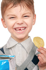 Image showing Little boy is eating chips