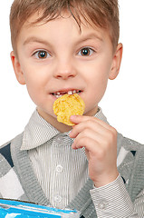 Image showing Little boy is eating chips