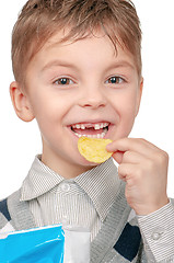 Image showing Little boy is eating chips