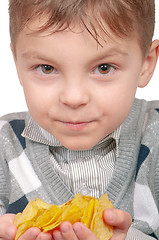 Image showing Little boy is eating chips