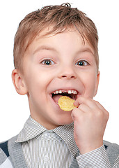 Image showing Little boy is eating chips