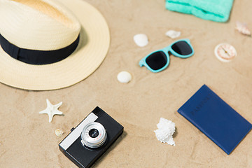 Image showing camera, passport, sunglasses and hat on beach sand