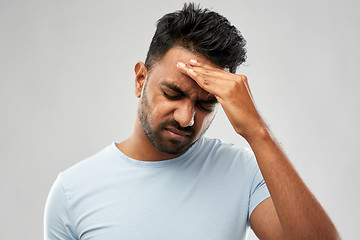Image showing unhappy indian man suffering from headache