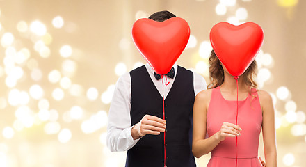 Image showing couple hiding behind red heart shaped balloons