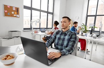 Image showing creative man with laptop working at office