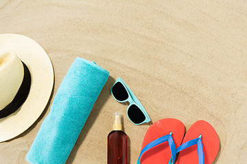 Image showing straw hat, flip flops and sunglasses on beach sand